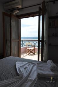 皮加迪卡Zennova #42 Pirgadikia Sky & Sea Home的一间卧室设有一张床,享有阳台的景色