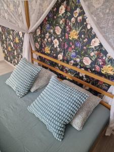 BučoviceGLAM apartmán Bučovice的一张带枕头的床和花卉墙
