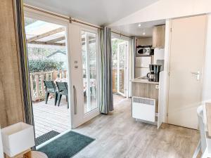 罗克布伦河畔阿尔让3 bedroom Chalets Camping Leï Suves - JoyCasa的厨房设有滑动玻璃门,可通往庭院。