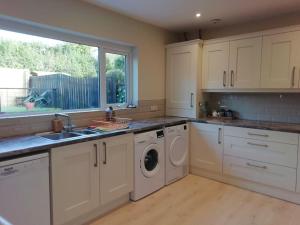 班戈北爱尔兰Beechwood的厨房配有水槽和洗衣机