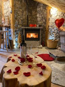 皮亚扎托雷ALLA STALLA Suite & Chalet的一间设有桌子的房间,配有酒杯和红玫瑰