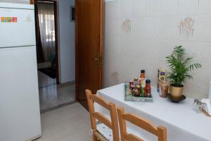 锡蒂亚Palaikastro Holiday Apartment的厨房配有白色桌子和白色冰箱。