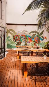 坎昆Nomads Hotel, Hostel & Rooftop Pool Cancun的壁画前的带桌椅的墙壁