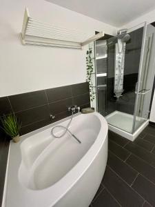 诺德豪森Appartement W@llstreet的带淋浴的浴室配有白色浴缸。