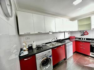 拉巴特La Terrasse de l'agdal的一间带红色橱柜和洗衣机的厨房