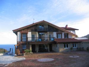 奥利奥依戈多农家乐的带阳台的房屋,背景为大海