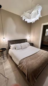 锡拉库扎Casa Adriana的卧室配有一张白色大床和吊灯。