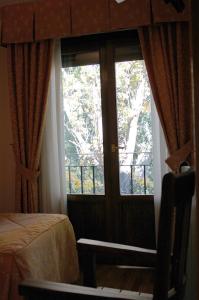 沙比纳尼哥Hotel Restaurante Santa Elena的一间设有窗户、一张床和一扇门的房间