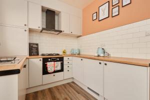 布雷得佛10 Percent OFF - 3 Nights - Leeds - Bradford - Free Parking的厨房配有白色橱柜和炉灶。