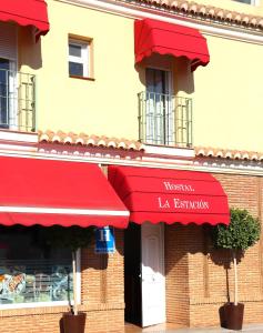 贝纳哈拉菲HOSTAL LA ESTACION的大楼内一间设有红色遮阳篷的餐厅