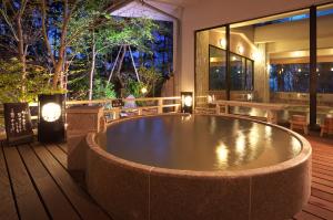 涩川市如心佐藤声场日式旅馆的餐厅甲板上的热水浴池