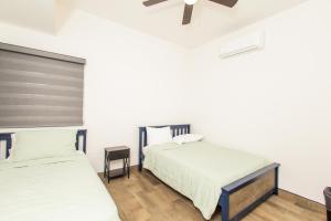 佩尼亚斯科港Residence 4的配有白色墙壁和木地板的客房内的两张床