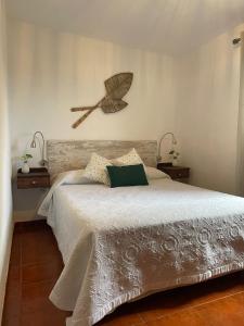 弗龙特拉La Casita de la Breña.的卧室配有一张大床,墙上有扫 ⁇ 