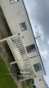 Kinmel BayWhitehouse Leisure Park North wales 6 birth caravan的一座高大的白色建筑,窗户在建筑的一侧