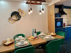 赞布热拉-杜马尔Zambujeira Terrace的一张带绿椅的餐桌和一间厨房