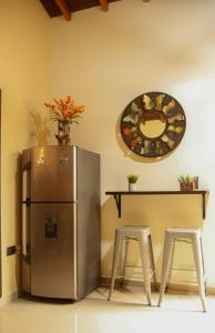 贝约Lindo apartamento con terraza en Bello Ant的厨房配有冰箱、桌子和2把凳子