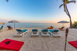 伊斯拉莫拉达Beachfront Villa at Islamorada BY THE GLAMHOMES的海滩上的一组椅子和遮阳伞