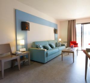 佩罗斯-吉雷克皮埃尔假日酒店的客厅配有蓝色的沙发和桌子