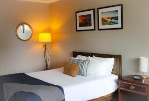 南太浩湖埃尔德酒店的卧室配有一张床,墙上挂有两张照片