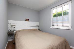 欧巴德伍斯图Strandnest的白色的卧室设有床和窗户