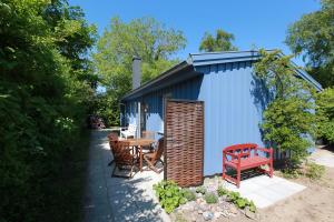 欧巴德伍斯图Strandnest的蓝色的棚子,有红色的长凳和一张桌子