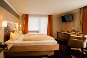 柯尼希斯湖畔舍瑙布鲁奈克阿本酒店的配有一张床和一张书桌的酒店客房