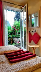 施特罗布尔格里尔公寓酒店的窗户前的一张带红色枕头的床