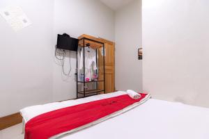 秾莎RedDoorz near Hang Nadim Batam Airport的一间卧室配有一张床铺,床上铺有红色毯子