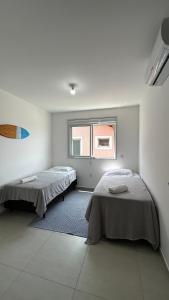 弗洛里亚诺波利斯Casa em Floripa - 200m da praia的白色客房的两张床,设有窗户