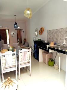 日惹rindoe jogja holiday home的一间厨房,内设桌子和椅子