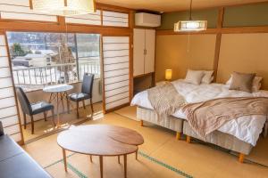 信浓Elan Hotel Lake Nojiri的卧室配有一张床和一张桌子及椅子