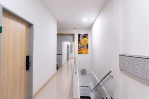 JabiUrbanview Hotel R House Batam的一条带白色墙壁和白色楼梯的走廊
