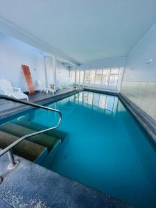 伊基克Departamento con espectacular Ubicación, Vista al Mar y Panorámica a todo Iquique的大楼内一个蓝色的大型游泳池