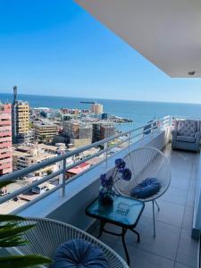 伊基克Departamento con espectacular Ubicación, Vista al Mar y Panorámica a todo Iquique的阳台配有桌子,享有海景。