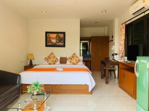 卡塔海滩达简易别墅的一间卧室配有一张床、一张书桌和一台电视