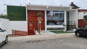 阿里卡Suites & Habitaciones Acapulco La Lisera的一座房子,有红色的门,外面有一辆汽车