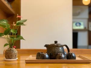台南末廣通一館 日式包棟民宿 Suehirodori Japanese Entire Homes No1的茶壶和桌子上的花瓶托盘