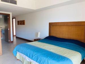 伊斯塔帕Condominio en Ixtapa frente a la playa的一间卧室配有一张大床和木制床头板