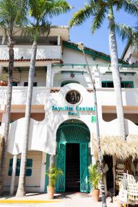 萨尤利塔Sayulita Central Hotel的一座带绿门和棕榈树的建筑