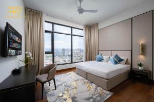 吉隆坡Pavilion Embassy Suites KL的一间卧室配有一张床、一张书桌和一个大窗户
