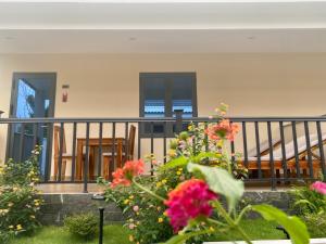 富国LAM BUNGALOW Resort & Spa的庭院内的阳台配有椅子和鲜花