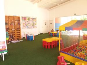 卡达斯诺瓦斯L'acqua DiRoma - Gran Caldas Reservas的一间铺有绿色地毯并配有五颜六色桌椅的教室