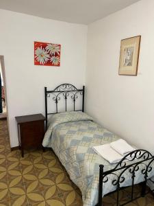奥斯图尼Trullo La Quercia的一间卧室配有一张床、一张桌子和一张图片