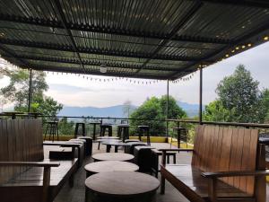 河内Villa Ba Vì MEMORY HOME的餐厅配有桌椅,位于山脉的背景中