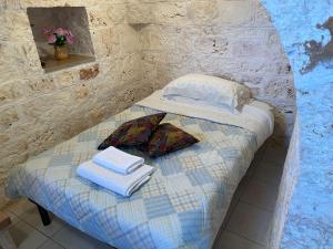 奥斯图尼Trullo L'ulivo的一张小床,房间里备有毛巾