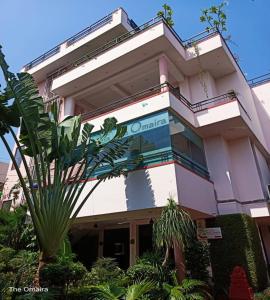 斋浦尔Hotel The Omaira的前面有棕榈树的建筑