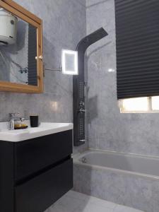 马达巴Laura's Cozy HOME的浴室配有盥洗盆和浴缸。