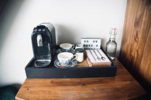 科芙Modern Penthouse Apartment in Cobh Town的咖啡壶和木桌上的杯子