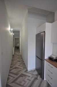 干尼亚Apartments Chania的走廊通往带冰箱的厨房