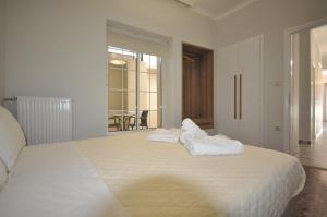 干尼亚Apartments Chania的卧室配有带毛巾的大型白色床